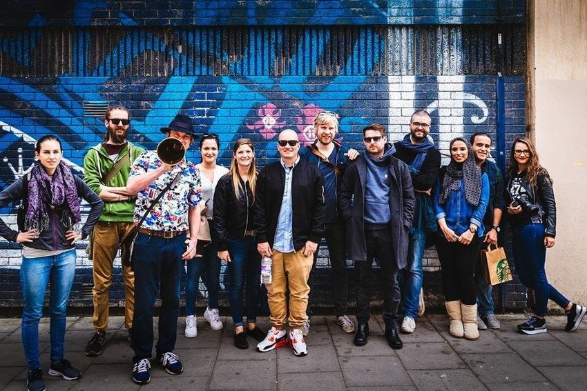 A group of people in front of street art