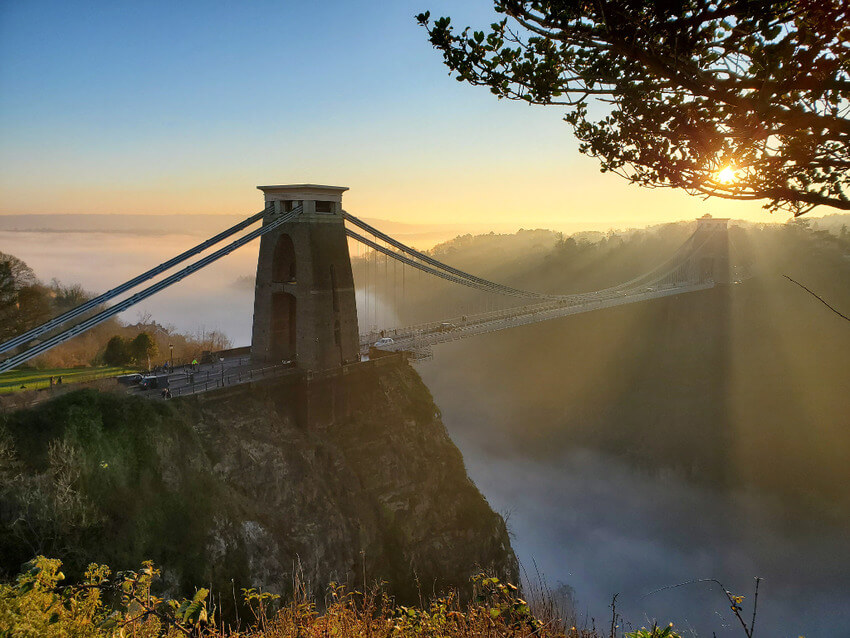 Clifton Suspension Bridge with the sun behind and mist in the valley