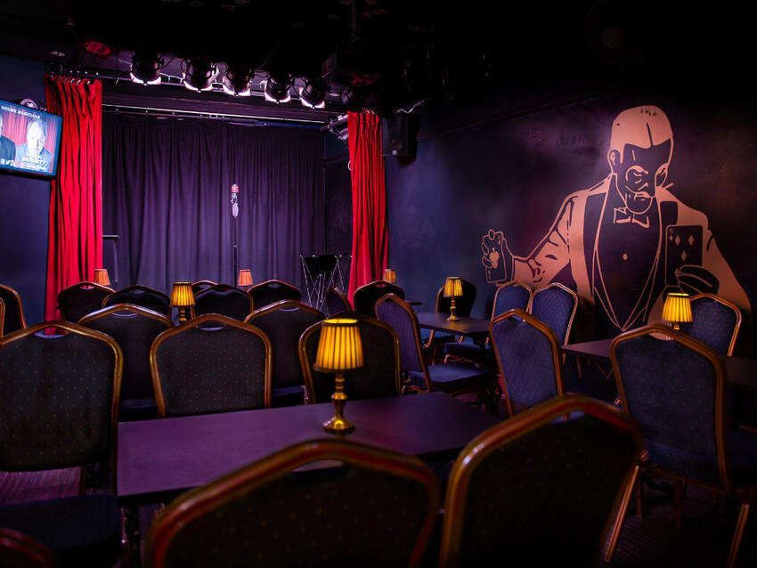 Empty chairs and stage inside Smoke & Mirrors theatre pub