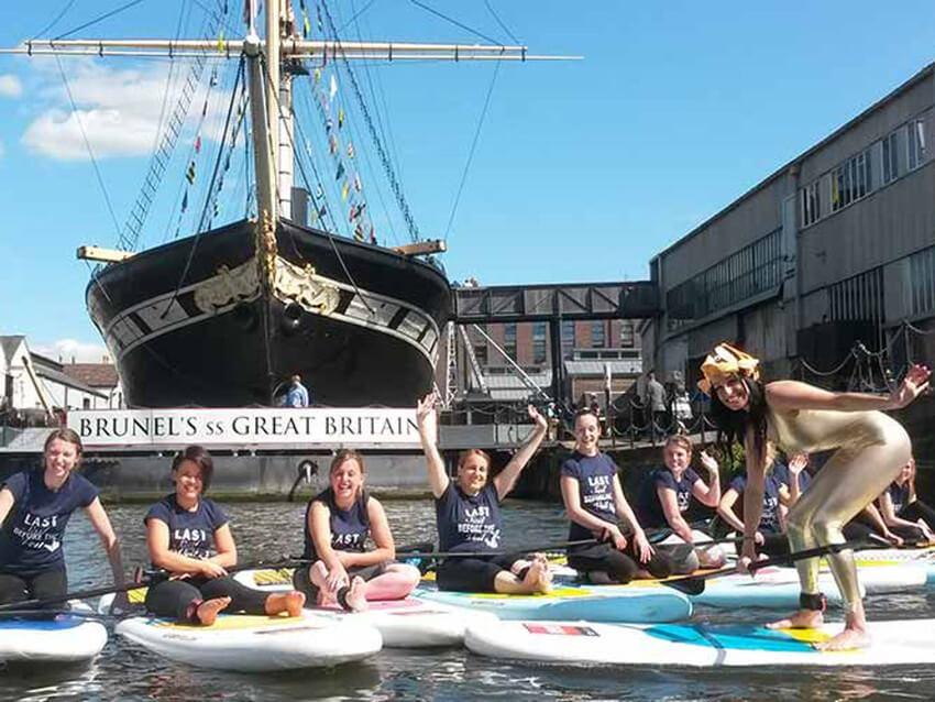 A group of girls in on paddleboards in front of the SS Great Britain
