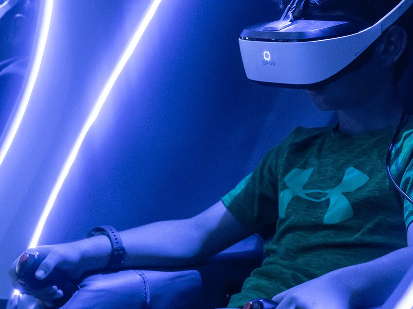A person with a headset in a virtual reality pod